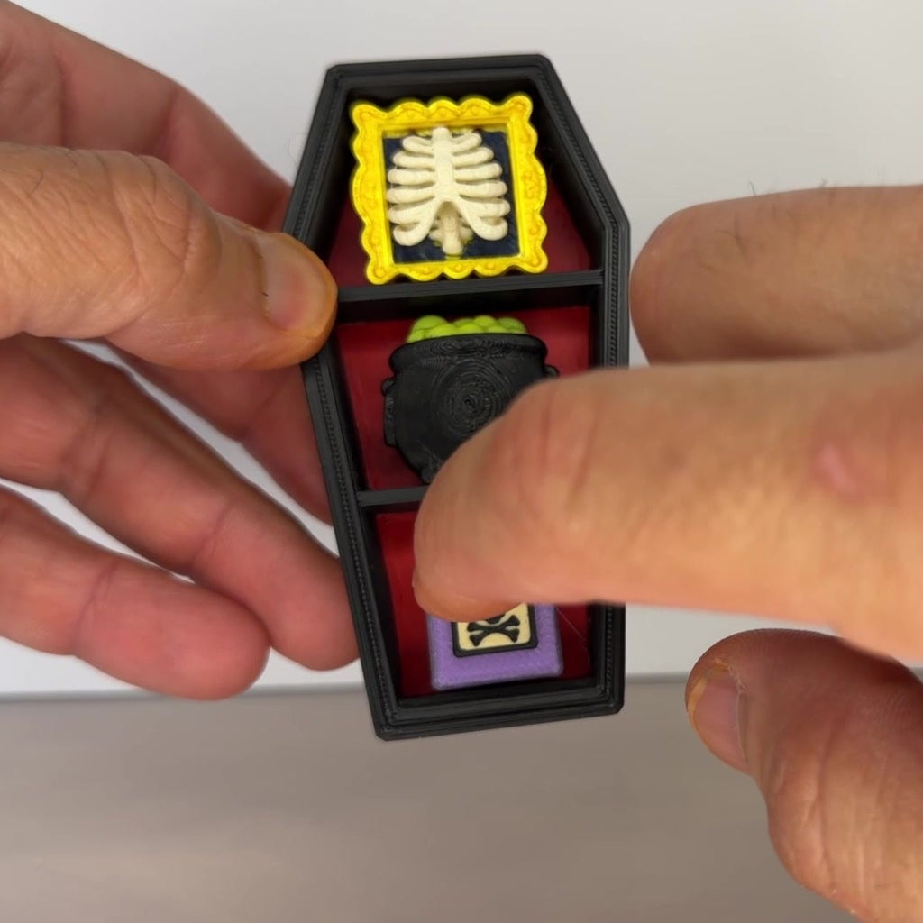 Hand clicking a coffin clicker with ribcage, cauldron and poison bottle keycaps